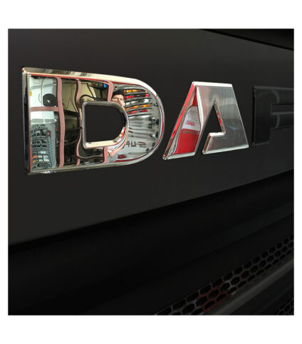 Logótipo da marca DAF em relevo prateado.